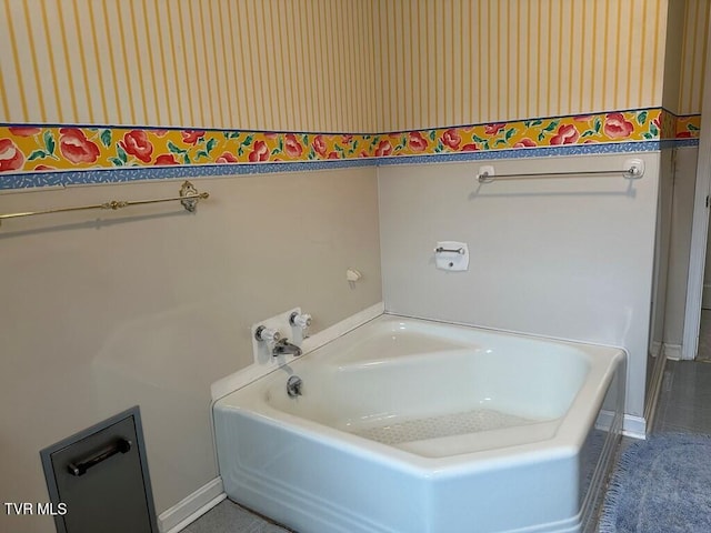 bathroom featuring baseboards and a garden tub