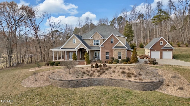 craftsman-style home with an outbuilding, covered porch, a front yard, and a garage