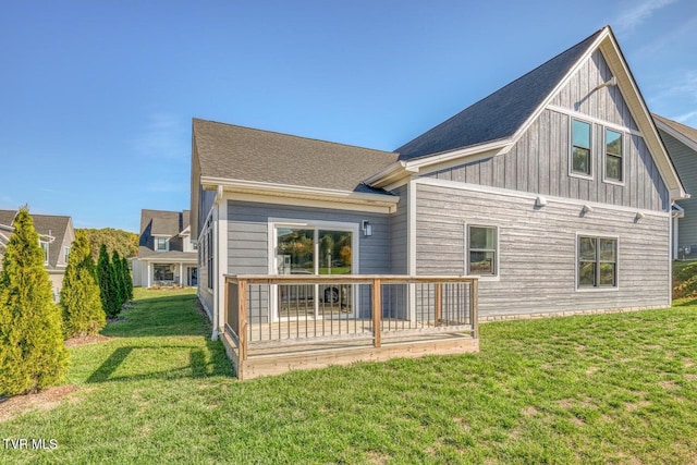 rear view of property featuring a lawn and a deck