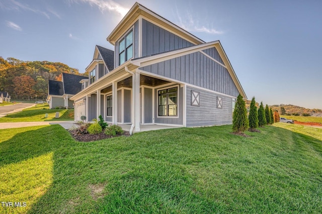 view of side of property with a yard, board and batten siding, and driveway