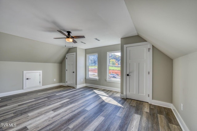 additional living space with visible vents, baseboards, lofted ceiling, and wood finished floors