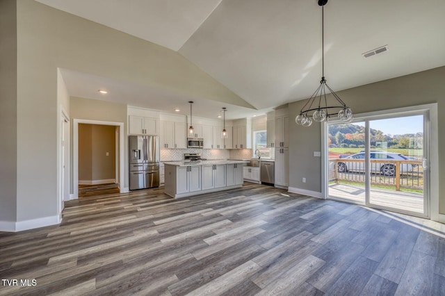 kitchen with visible vents, backsplash, light countertops, wood finished floors, and stainless steel appliances