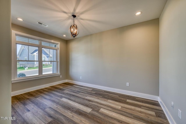 unfurnished room featuring visible vents, baseboards, recessed lighting, dark wood-style floors, and a notable chandelier