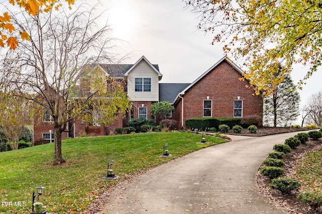 view of front of property featuring a front yard and brick siding