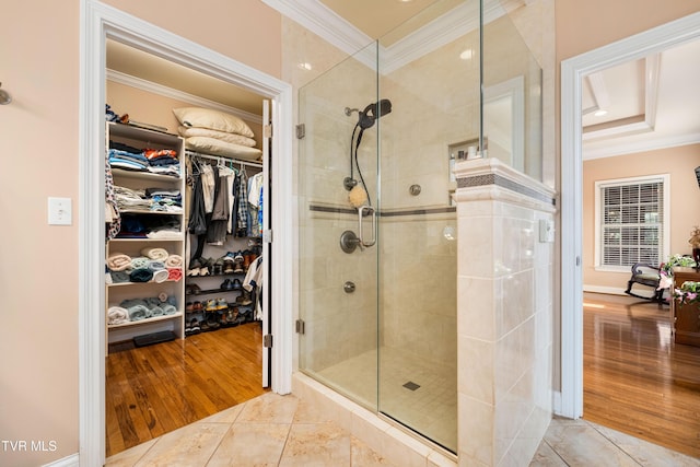 full bathroom featuring tile patterned flooring, crown molding, a spacious closet, and a shower stall