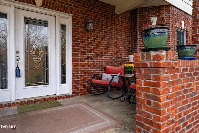 doorway to property featuring brick siding