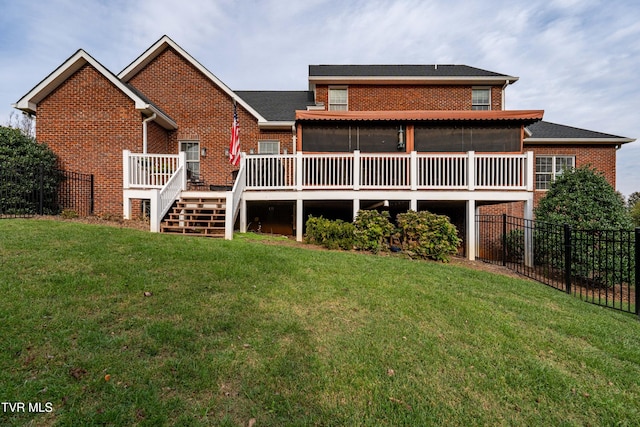 back of property with brick siding, a lawn, and fence