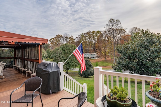 wooden deck with grilling area, a lawn, and fence