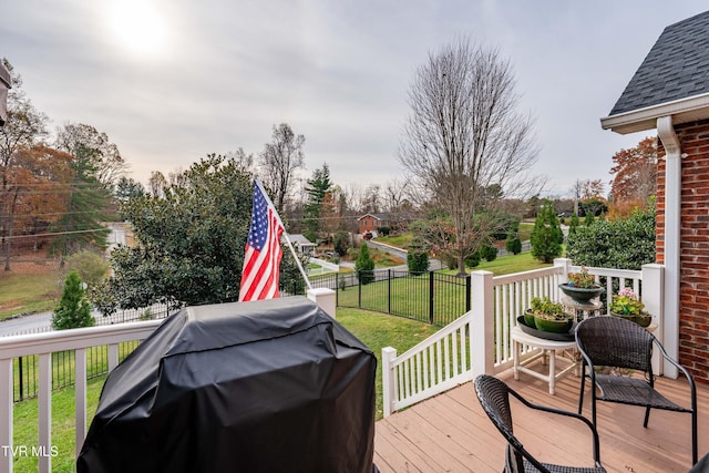 wooden terrace featuring grilling area, a yard, and a fenced backyard