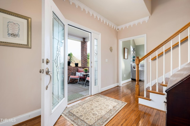 foyer entrance with stairway, baseboards, french doors, and hardwood / wood-style flooring