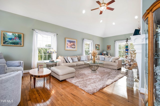 living room featuring vaulted ceiling, baseboards, ceiling fan, and hardwood / wood-style flooring