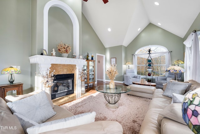 living area featuring high vaulted ceiling, a ceiling fan, wood finished floors, recessed lighting, and a fireplace