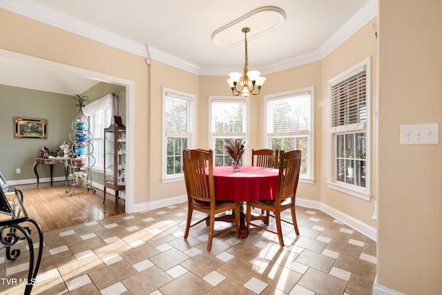 dining space featuring baseboards, an inviting chandelier, and ornamental molding