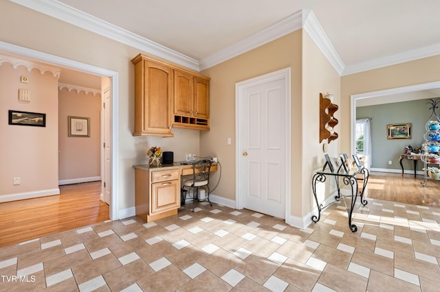 interior space with crown molding, light wood-style flooring, baseboards, and built in study area