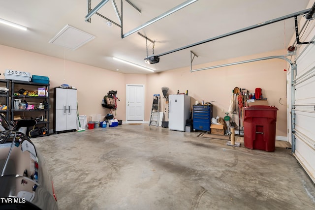 garage featuring freestanding refrigerator and a garage door opener