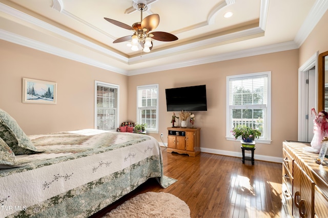 bedroom with dark wood-style floors, multiple windows, baseboards, and a tray ceiling