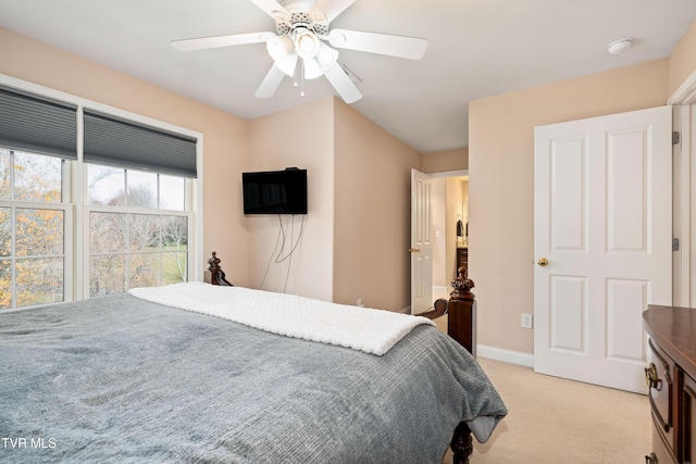 bedroom featuring light colored carpet, baseboards, and ceiling fan