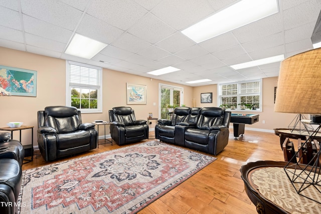 living area with a drop ceiling, pool table, baseboards, and light wood-style floors