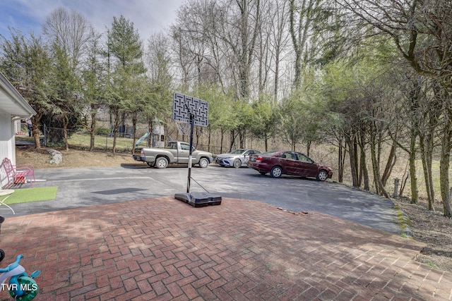 view of vehicle parking with fence