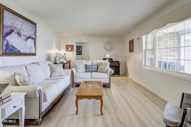 living area with a fireplace, baseboards, crown molding, and light wood-style floors