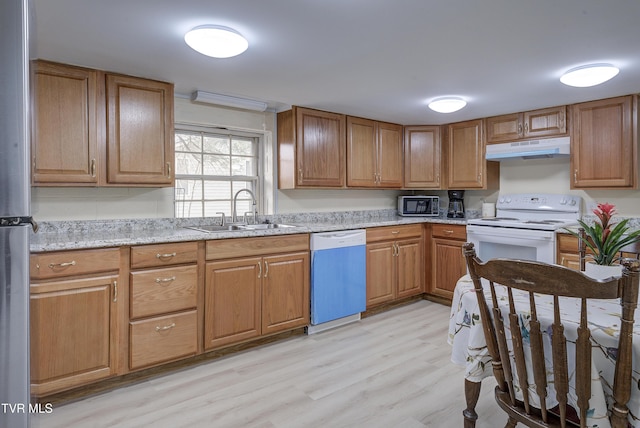 kitchen with under cabinet range hood, dishwasher, light wood-style flooring, white electric stove, and a sink