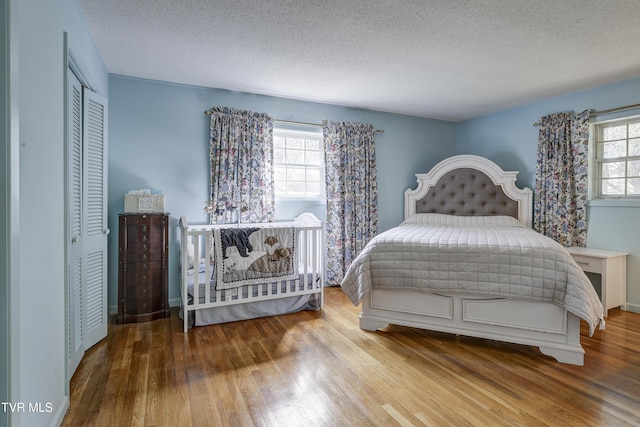 bedroom featuring a closet, a textured ceiling, and wood finished floors