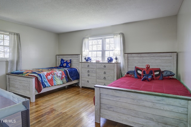 bedroom with wood finished floors and a textured ceiling