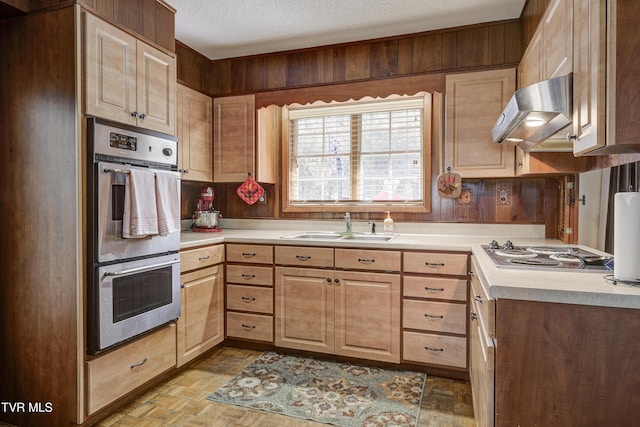 kitchen with range hood, stainless steel appliances, a sink, light countertops, and a textured ceiling