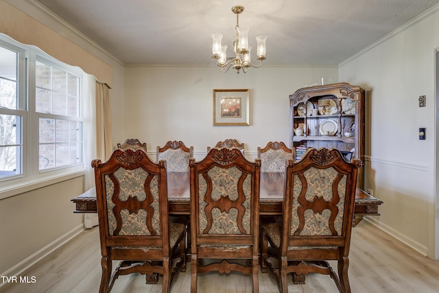 dining area with a notable chandelier, baseboards, light wood-style floors, and ornamental molding