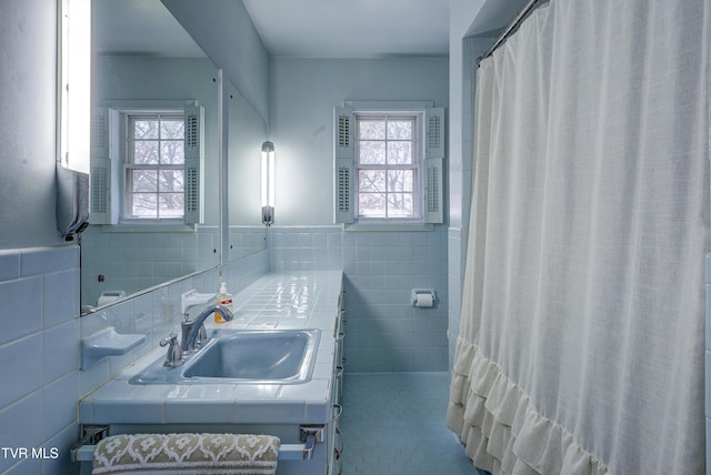 full bath featuring a wainscoted wall, tile walls, and vanity