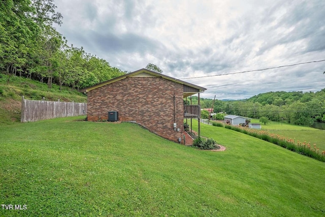 view of yard featuring central AC and fence