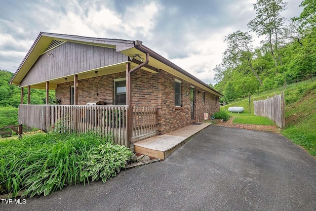 view of property exterior featuring brick siding and fence