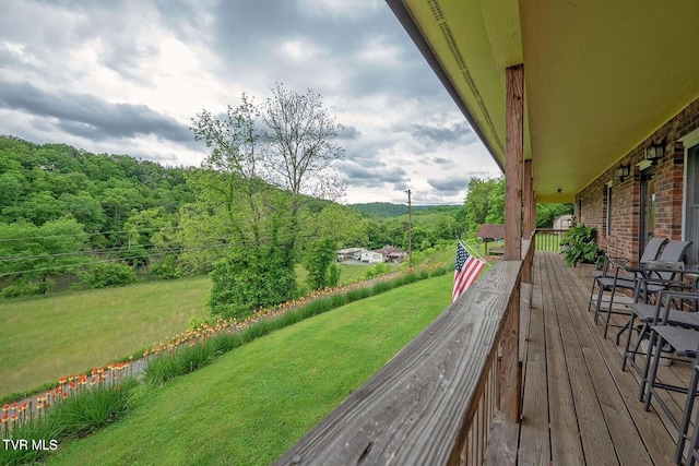 wooden terrace featuring a yard and a wooded view