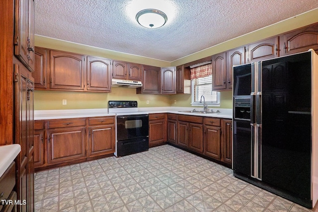 kitchen with light floors, a sink, electric stove, under cabinet range hood, and black refrigerator with ice dispenser