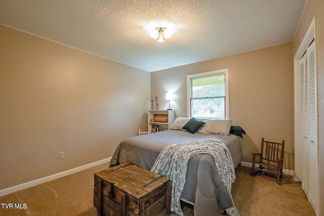 carpeted bedroom featuring baseboards, a closet, and a textured ceiling