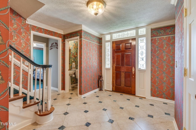 tiled foyer featuring crown molding, stairs, a textured ceiling, and baseboards