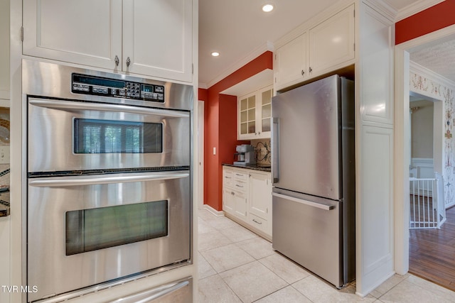 kitchen featuring crown molding, light tile patterned floors, white cabinets, and stainless steel appliances