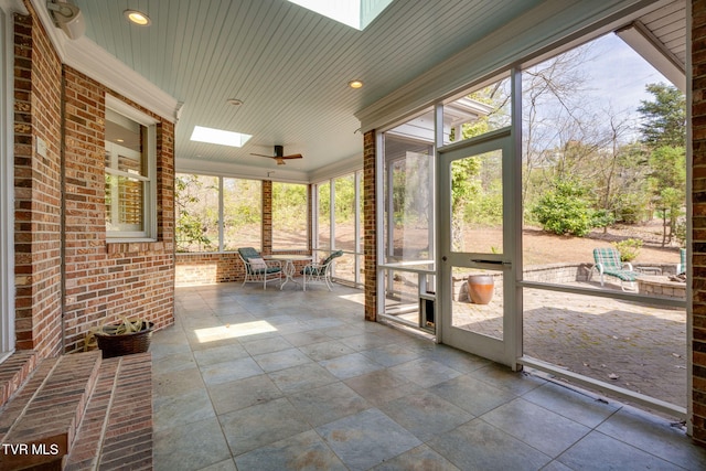 unfurnished sunroom with a skylight and ceiling fan