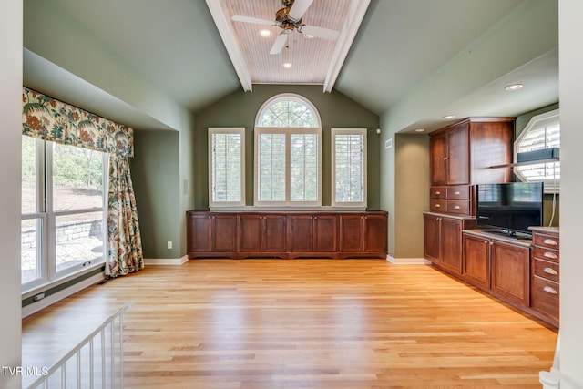 unfurnished living room with baseboards, ceiling fan, vaulted ceiling with beams, and light wood-type flooring