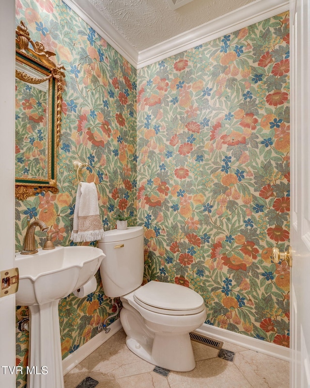 bathroom with baseboards, toilet, and wallpapered walls