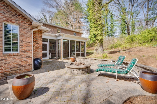 view of patio featuring a fire pit and a sunroom