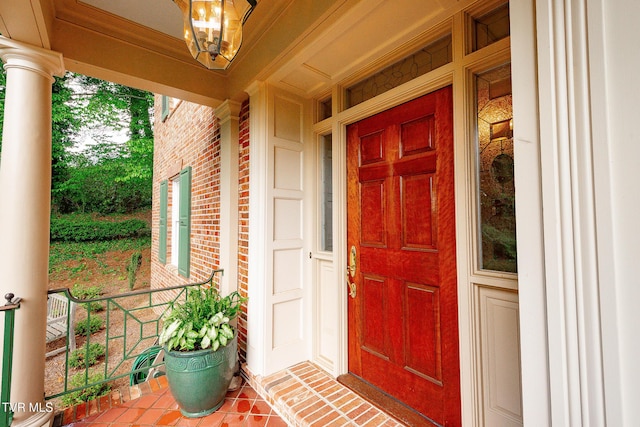 property entrance featuring covered porch and brick siding