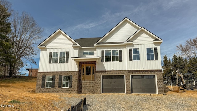 bi-level home featuring board and batten siding, a garage, brick siding, and driveway