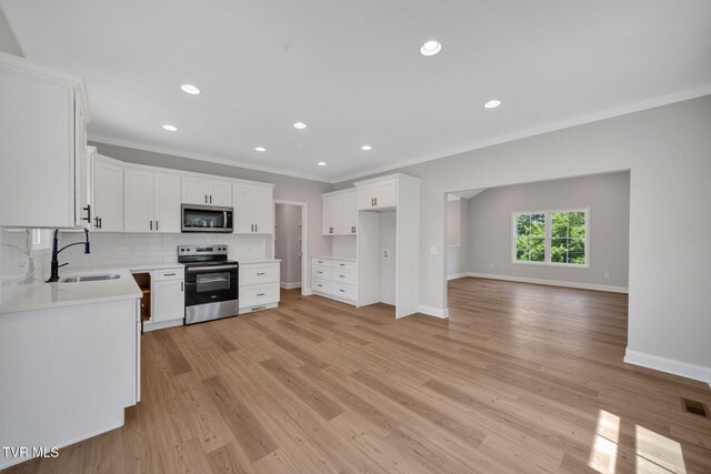 1110 Miller Dr, Jonesborough, TN 37659 - kitchen with appliances with stainless steel finishes, ornamental molding, backsplash, light wood-style flooring, and white cabinetry