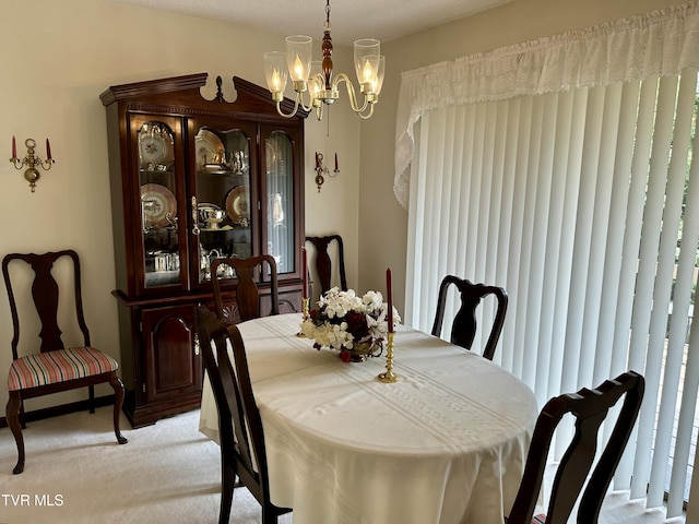 dining room with light colored carpet, an inviting chandelier, and vaulted ceiling