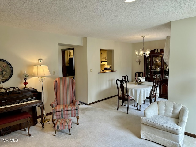 dining space featuring a textured ceiling, light carpet, baseboards, and a chandelier