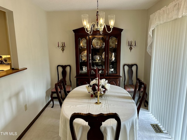 dining space with an inviting chandelier, baseboards, visible vents, and light carpet