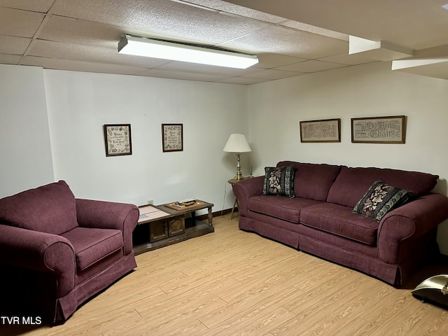 living area with wood finished floors, baseboards, and a drop ceiling