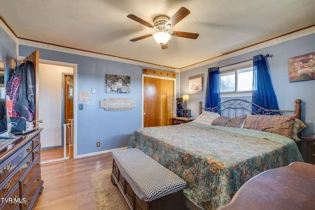 bedroom featuring baseboards, wood finished floors, and ornamental molding