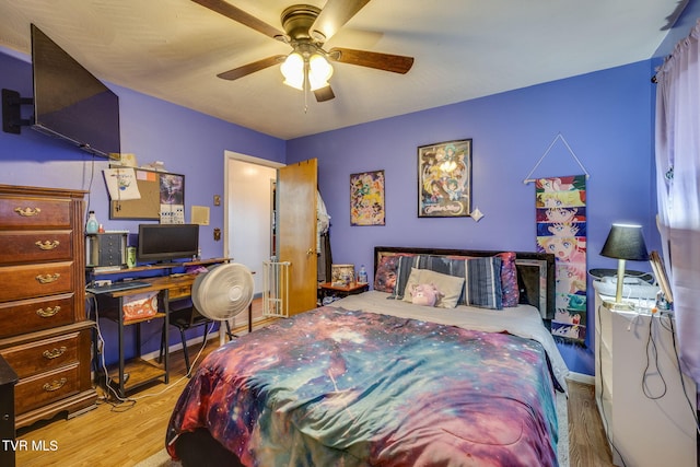 bedroom with ceiling fan, baseboards, and wood finished floors